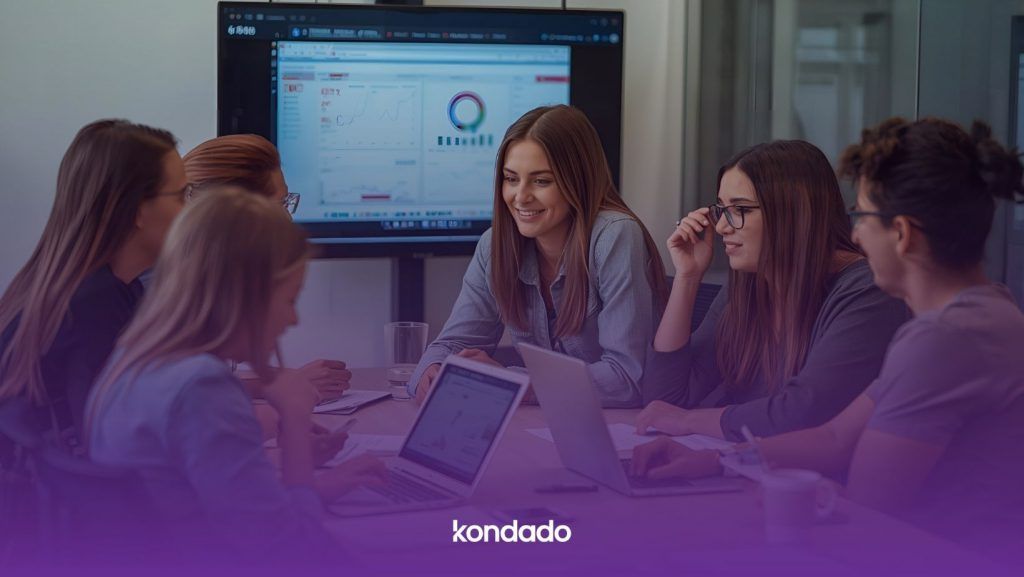 Equipe analisando métricas e gráficos em uma reunião, com dashboard exibido em tela ao fundo. Imagem criada com IA.